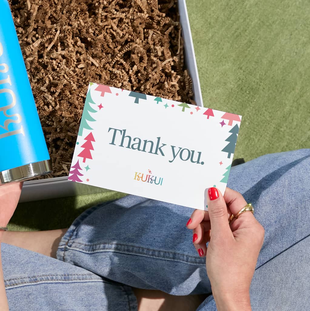 Hand holding a personalized "thank you" note